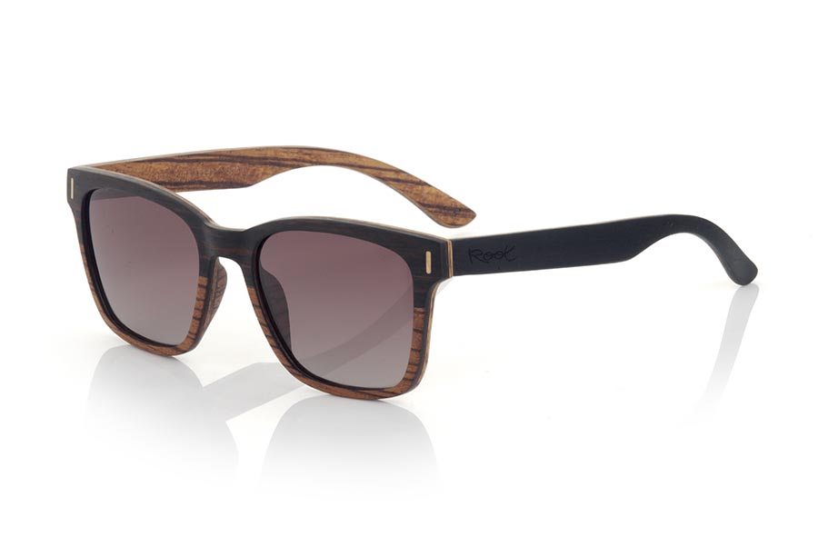 Wood eyewear of mpingo modelo LOREA. LOREA sunglasses are manufactured in a combination of two woods, Mpingo (African Black wood) on top of the frame and on the outside of the temples and Zebrano on the bottom of the frame and inside of the temples. It is a simple and elegant easy-to-wear model with a very careful finish that will surprise you with its originality and the combination of woods. Front measurement: 145x50mm | Root Sunglasses® 